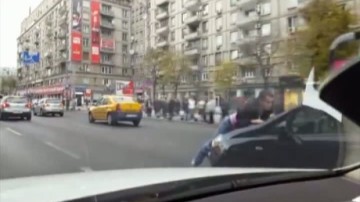 Scene şocante în trafic. Un tânăr e dus pe capotă câţiva km de o şoferiţă inconştientă - video