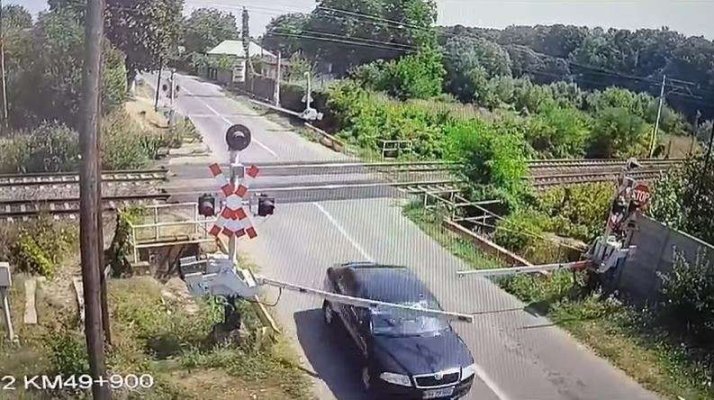 Şofer filmat în timp ce forţează şi rupe o barieră de cale ferată. Video 