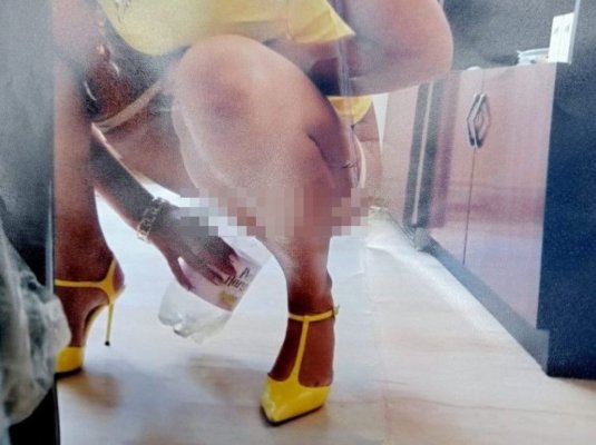 O angajată a unei primării, fotografiată în timp ce urinează într-un pet