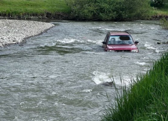 Un șofer a rămas împotmolit în mijlocul apelor, după ce a traversat un râu cu mașina