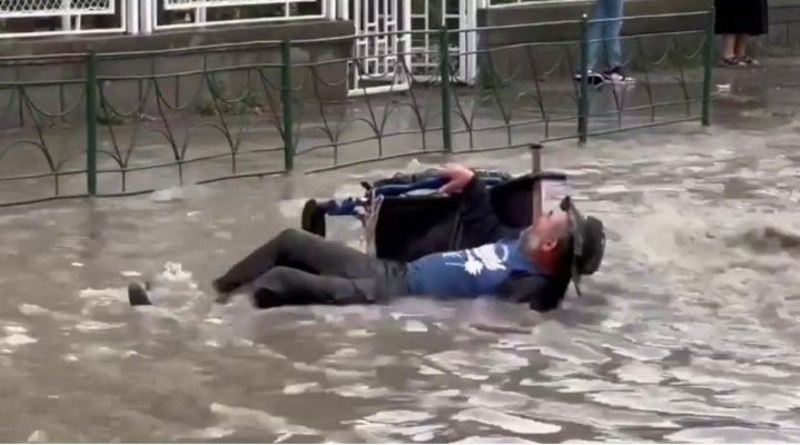 Un bătrân în scaun cu rotile a fost salvat din mijlocul viiturii de trecători