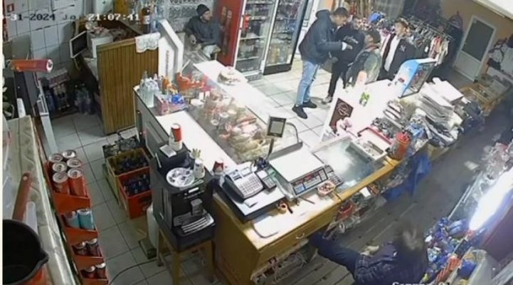 Bărbat snopit în bătaie printre rafturile unui magazin