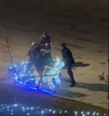 Filmare vulgară la un târg de Crăciun din România: sex mimat cu renii şi urinat lângă drapel 
