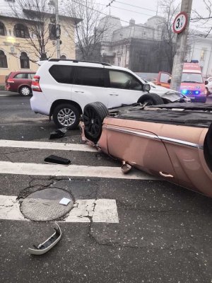 Un autoturism s-a răsturnat, după ce s-a izbit violent de un SUV parcat. Şoferul, un pasager şi un pieton au fost răniţi