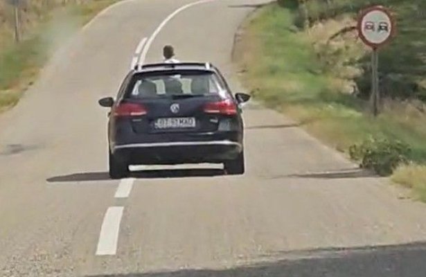Inconștiență la volan! Un șofer a condus mai bine de 30 de km cu un copil ieșit prin trapa mașinii. Video