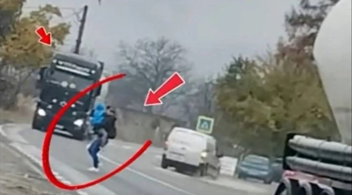 Mamă cu copilul în brațe, surprinsă traversând printre TIR-uri! Video