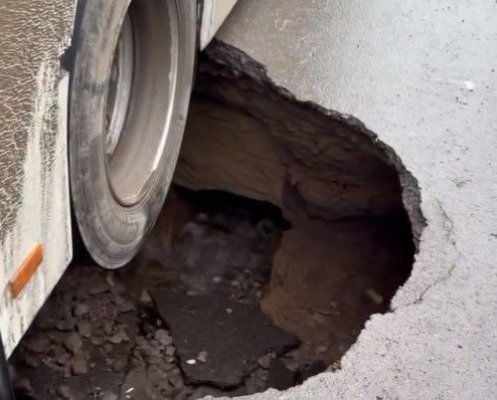 Un autobuz plin cu călători a rămas blocat într-o groapă uriaşă apărută în asfalt. Video