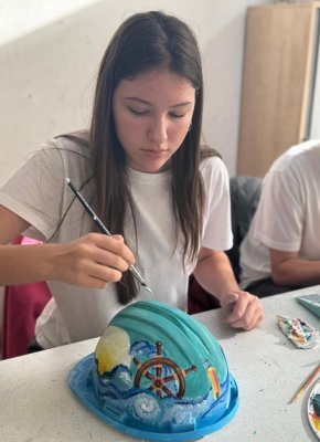 Compania IULIUS a invitat elevii Colegiului Național de Arte din Constanța să se exprime artistic pe un șevalet atipic, căști de protecție pe șantier