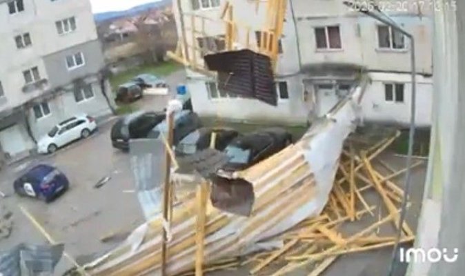 Vântul puternic face ravagii! A smuls acoperișul unui bloc și l-a aruncat peste mașinile din parcare. Video