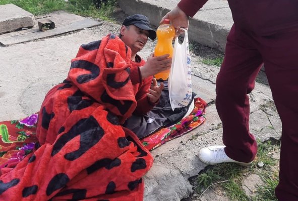 Un bărbat doarme sub cerul liber, pe o placă de beton care astupă o gură de canalizare, pe str. Nicolae Iorga