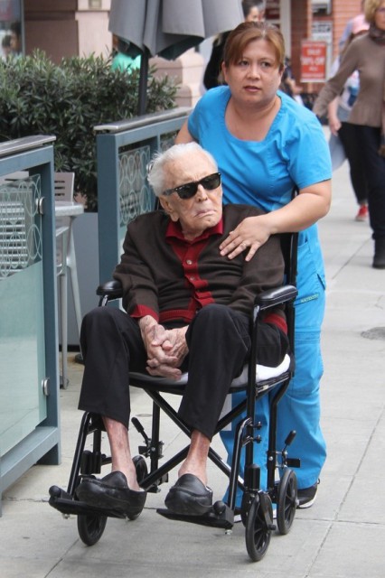 Kirk Douglas, scos la plimbare în scaunul cu rotile de asistenta personală. Actorul are 102 ani