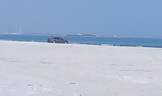 Mașină parcată pe plajă în buza mării