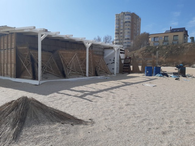 Dezastru ecologic! Barăcile 'demolate' de primărie încă stau la loc de cinste pe plaja din Faleză Nord