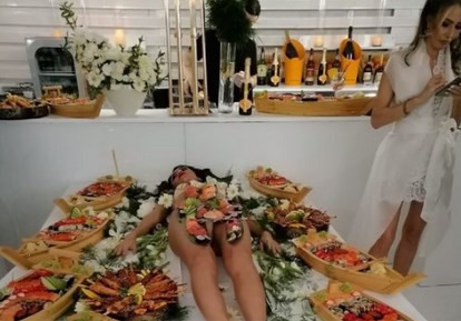 Cine este bruneta pozată aproape goală, folosită drept masă de sushi la un party cu vedete